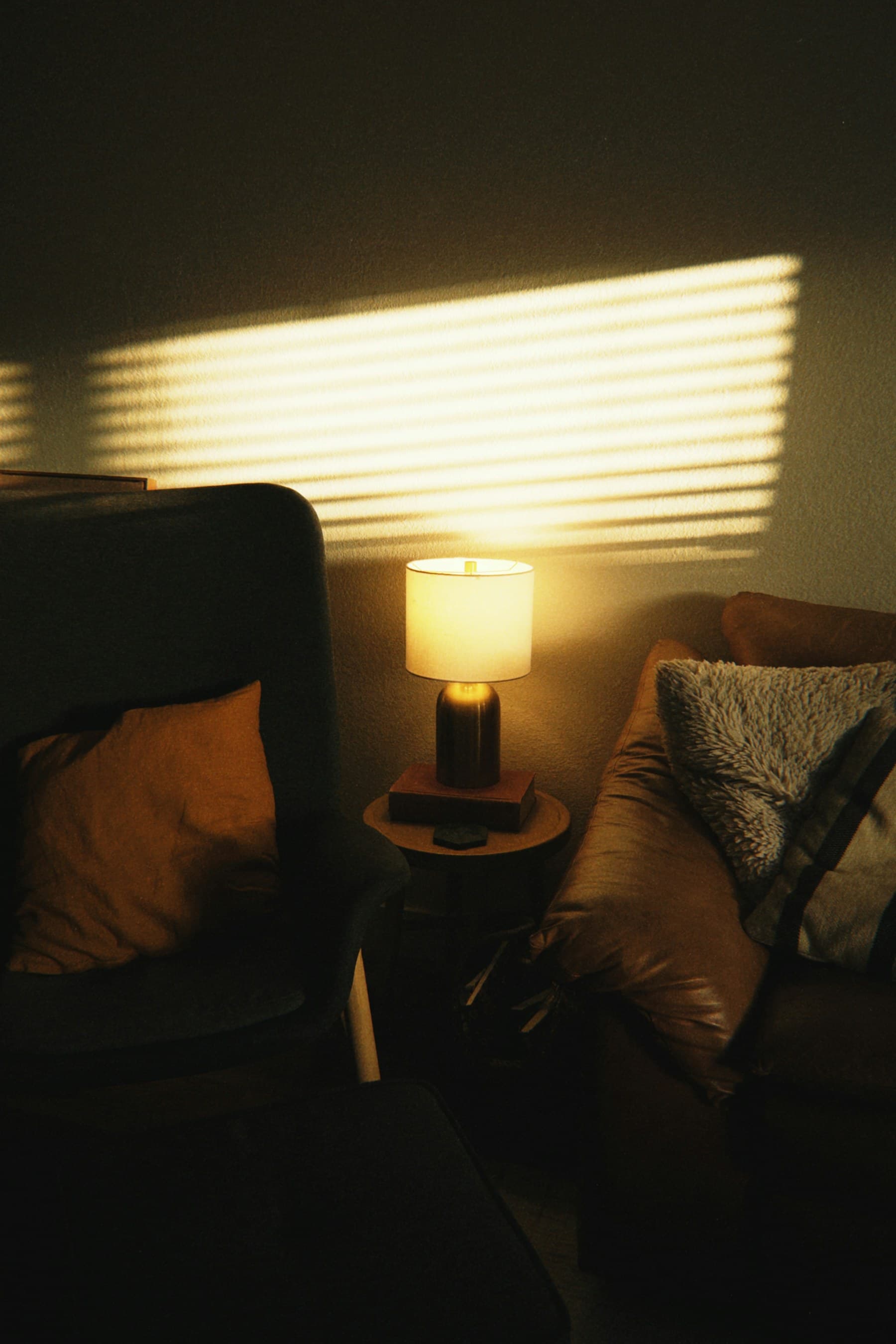 Luz do fim de tarde atravessando uma persiana e desenhando linhas na parede